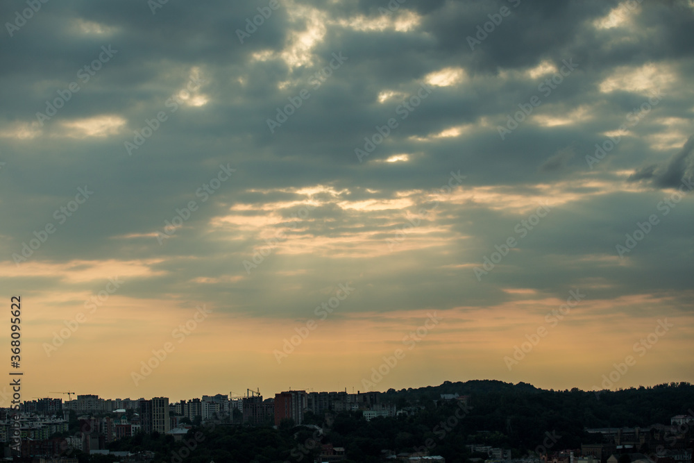 beautiful sunset with fluffy grey clouds on dramatic sky above cityscape silhouettes beautiful sunset with fluffy grey clouds on dramatic sky above cityscape silhouettes