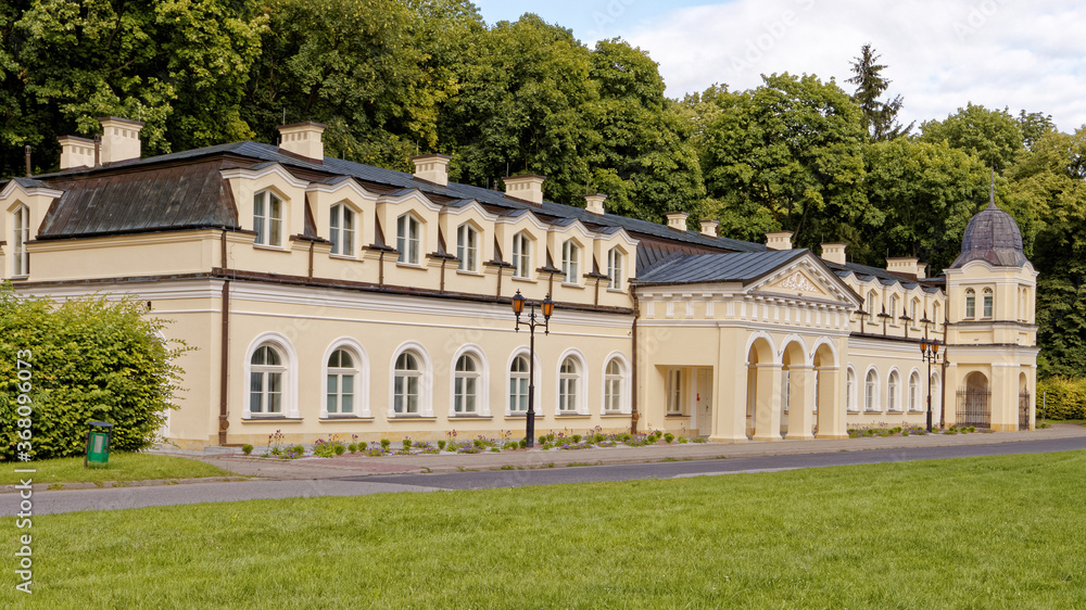 Neoclassical architecture style building in European town. Sunny day in park in Naleczow health resort in Poland.