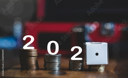 Number 202 and white paper dice showing number one on stacks British pound coins, Financial planing for 2021 New Year resolution for saving money for the future in business or personal life concept