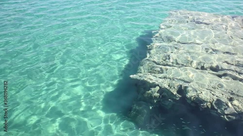Crystal clear turquoise water and small fish and square rock inside, in the area of Halkidiki Greece photo