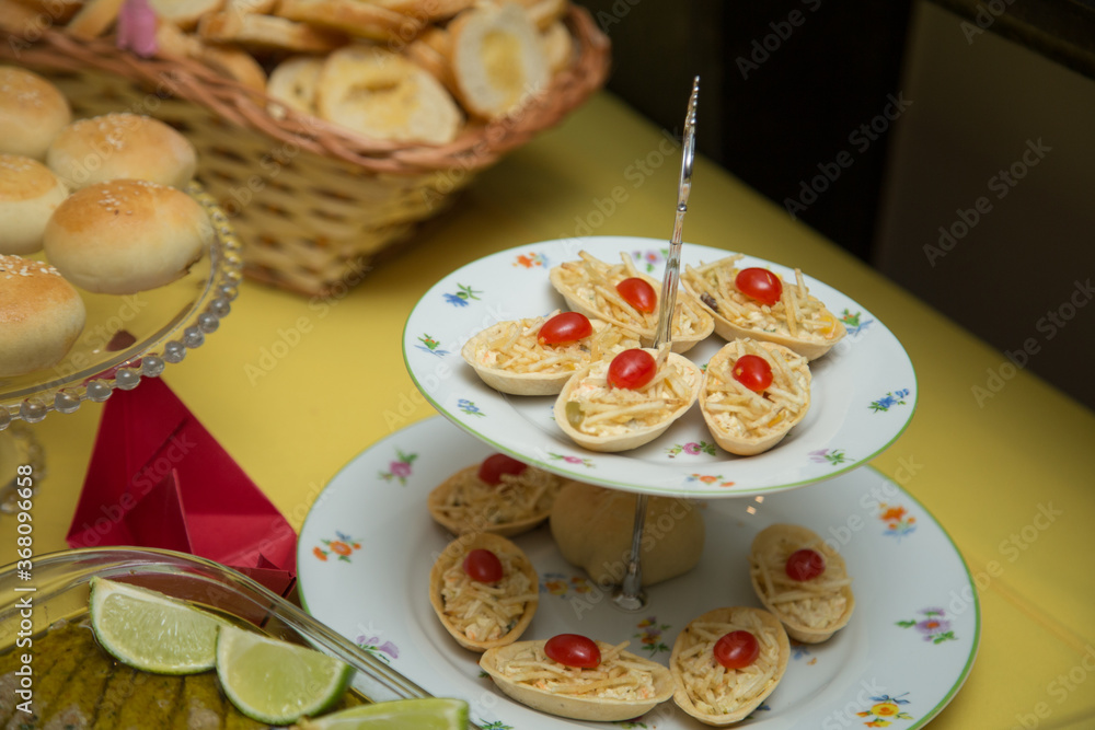 Fototapeta premium Salgados e pães em mesa de evento.