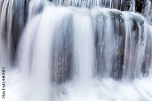 Smooth abstract water cascade at Jelen wild river. Nature water landscape. Landscape park Solska forest at Roztocze, Poland, Europe.