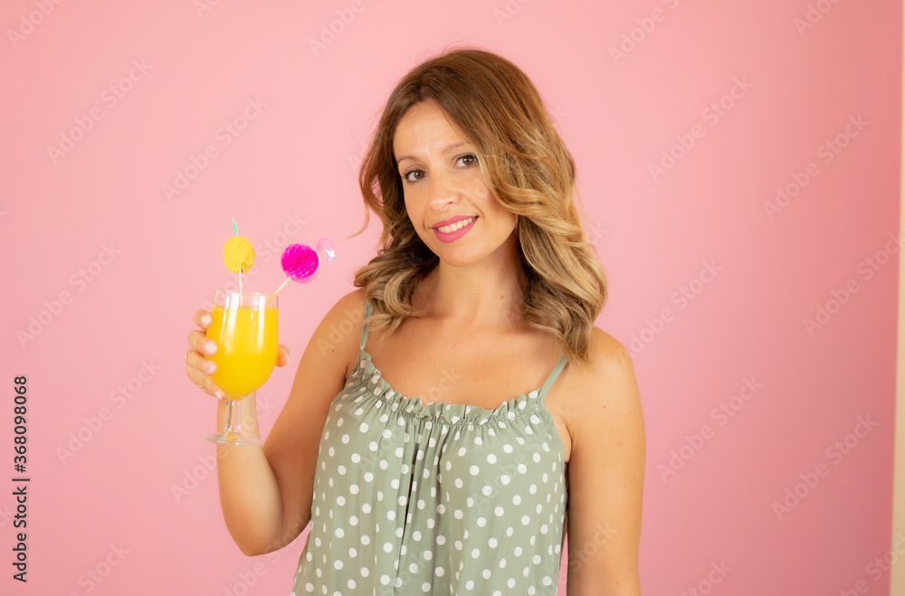 Woman with a cocktail on pink background Woman with a cocktail on pink background
