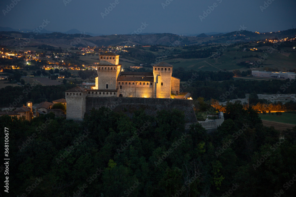 Obraz premium Il castello medievale di Torrechiara illuminata nella notte. Struttura antica nelle valle tra i castelli del Ducato di Parma sull'appenino Parmense.