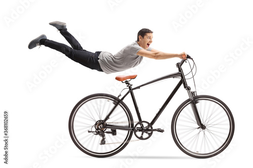 Guy flying and holding onto a bicycle