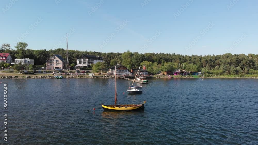 three boats anchored near the shore in sunny weather with reflections in the water three boats anchored near the shore in sunny weather with reflections in the water