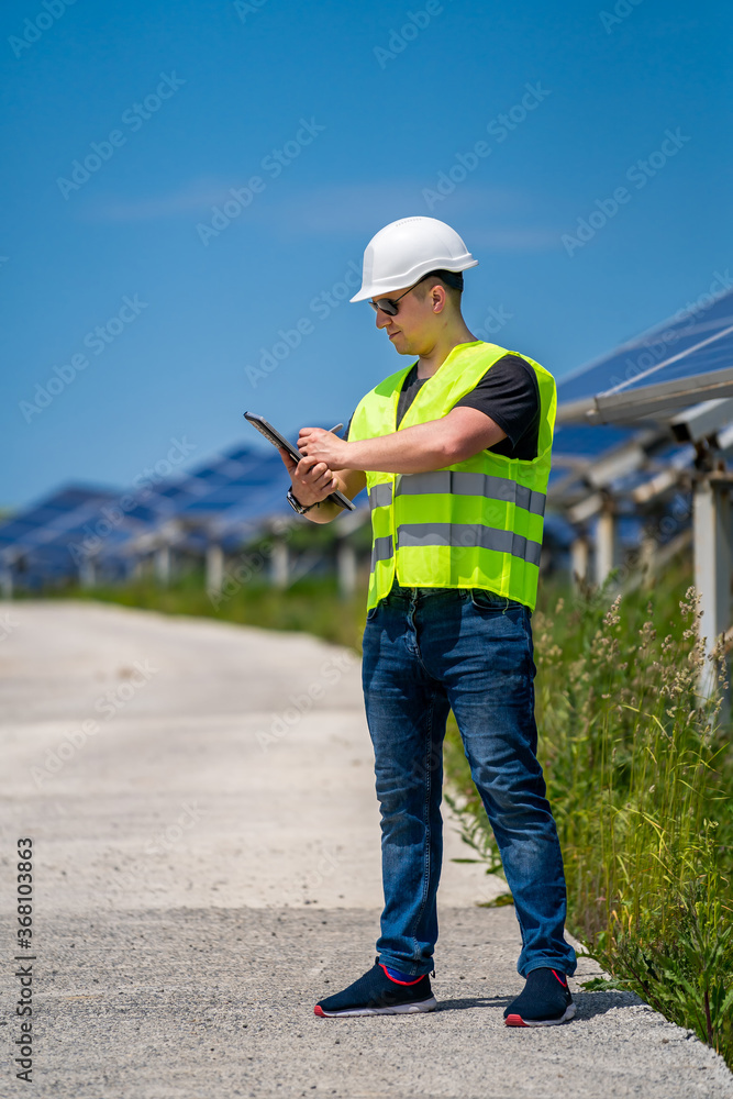 Engineer is checking installed solar panels at solar energy plant. Engineer is checking installed solar panels at solar energy plant.