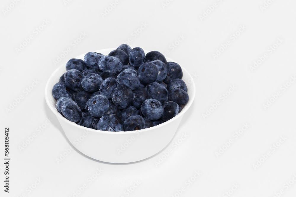Blueberries in a white ceramic bowl. On a white background. Blueberries in a white ceramic bowl. On a white background.