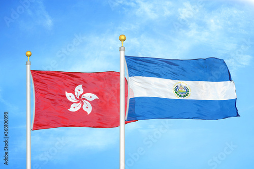 Hong Kong and El Salvador two flags on flagpoles and blue cloudy sky photo