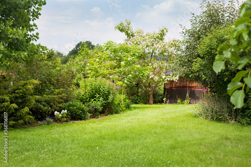 Foto Summer house in the beautiful backyard green garden landscape and fresh, green lawn background with a lot pf space