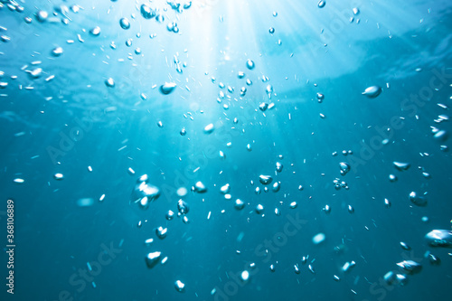 Underwater light creates a beautiful veils, consisting of sunlight. Underwater ocean waves and bubbles.