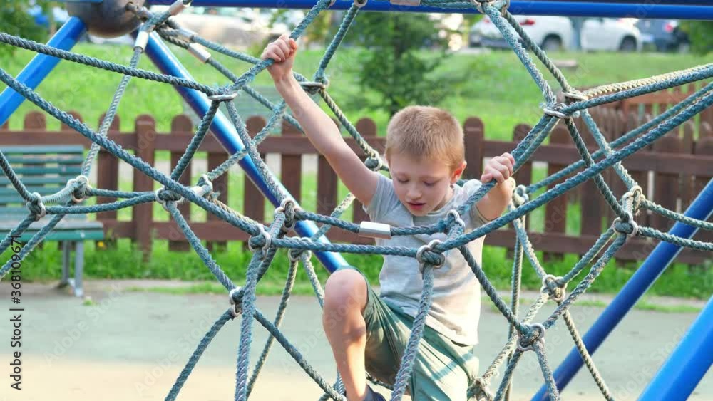 A young child climbs and has fun on the playground. A young child climbs and has fun on the playground.