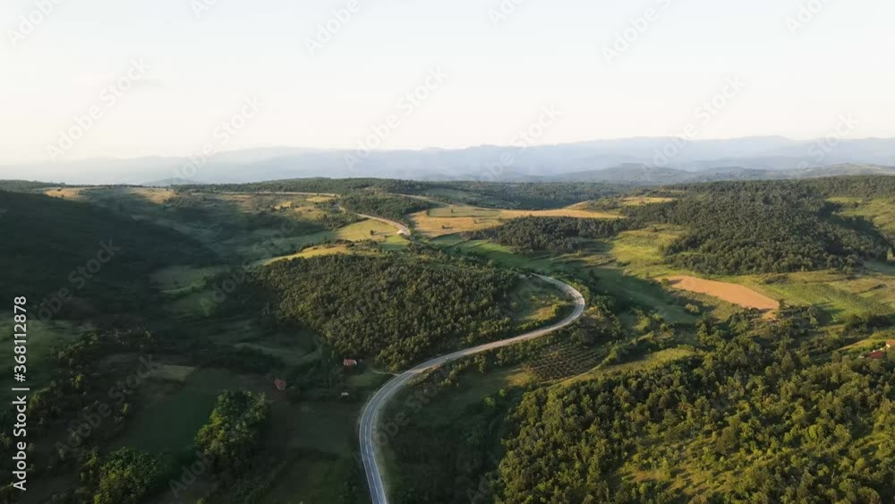 Aerial view from above on the country road in mountain range in between green grass and trees around - nature travel concept drone photo on Tresibaba in Europe Serbia in sunny summer day or evening Aerial view from above on the country road in mountain range in between green grass and trees around - nature travel concept drone photo on Tresibaba in Europe Serbia in sunny summer day or evening