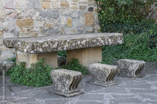 Stone table and chairs. Resting place for three people. Three objects. Anti-vandal outdoor furniture. Carve out of stone. Medieval architecture. A haven for the weary traveler. On the Pilgrim's Path.