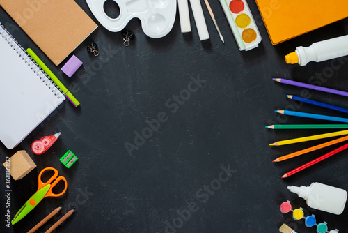 School supplies on black board background. Back to school concept. Frame, flatlat, copy space for text