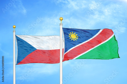 Czech and Namibia two flags on flagpoles and blue cloudy sky