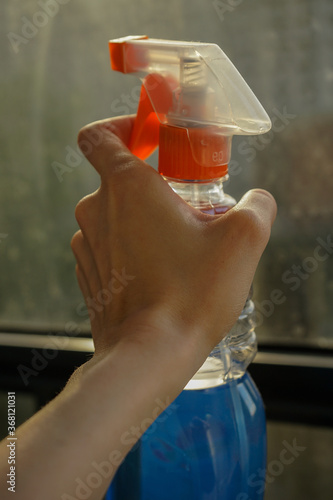 windshield wiper with blue water in hands on the background of the window