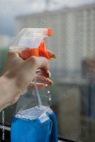 windshield wiper with blue water in hands on the background of the window