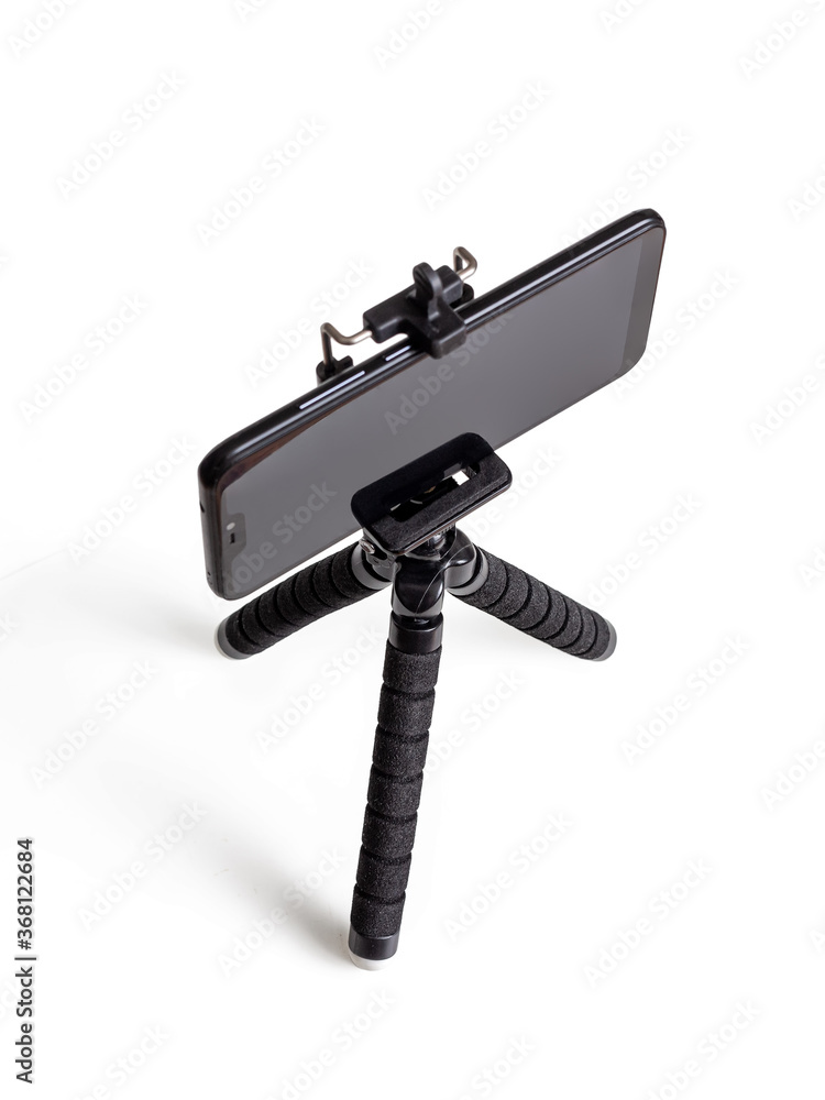 Black mini tripod with fixed black phone on white background Black mini tripod with fixed black phone on white background