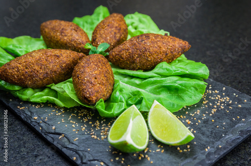 Delicious Lebanese  food, kibbeh (kibe) on black slate stone and granite background. photo