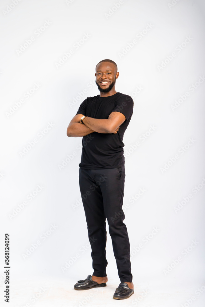 young black handsome man standing and folding his arms in front of a white background young black handsome man standing and folding his arms in front of a white background