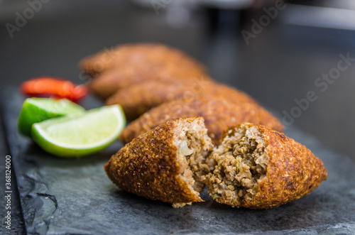 Delicious Lebanese  food, kibbeh (kibe) on black slate stone and granite background. photo