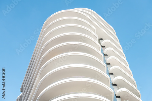 Wallpaper Mural Architecture, exterior facade abstract view of modern residential, apartment, condo, condominium building wall with lights and shadows with wave shapes isolated against blue sky Torontodigital.ca