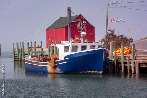 Fishing Boat docked in Halls Harbour Nova Scotia on a foggy day.