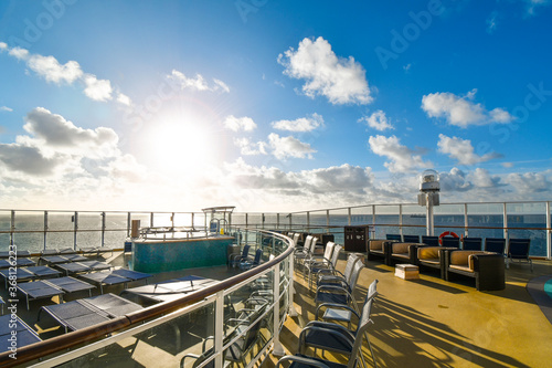 Bilde på lerret An empty cruise ship upper deck on an unidentifiable large cruise ship liner on the sea as the sun sets over the ocean