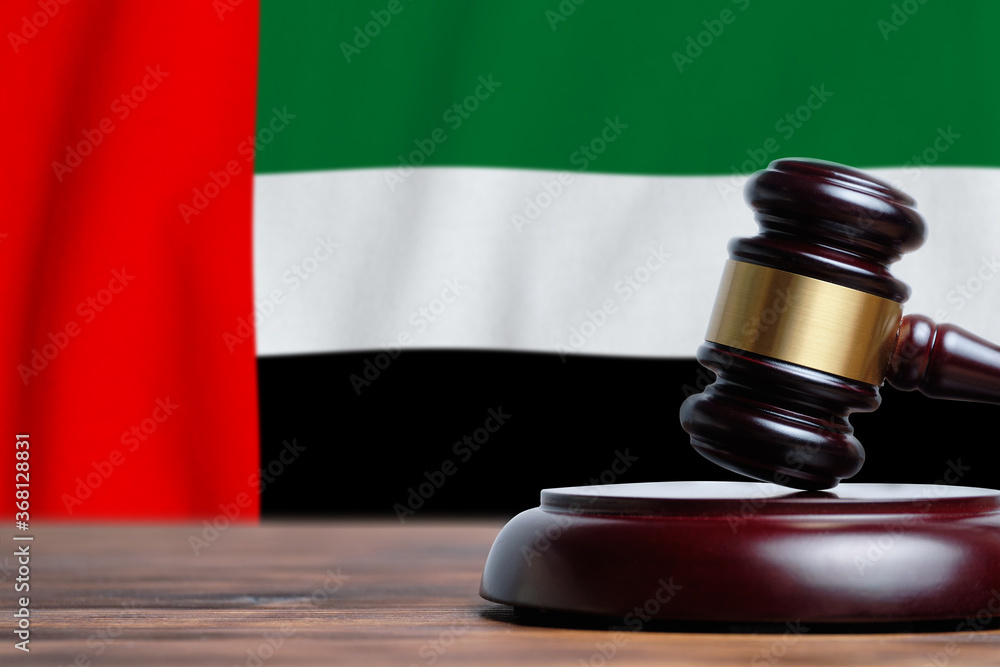 Justice and court concept in United Arab Emirates. Judge hammer on a UAE flag background