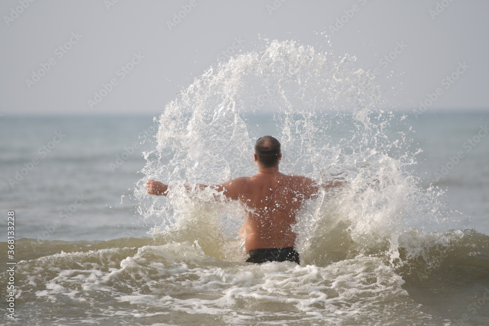 Man running in water with splashes