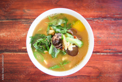 Thai Spicy Mixed Vegetable Soup with Prawns in bowl on wooden table , top view - Thailand food of Asian