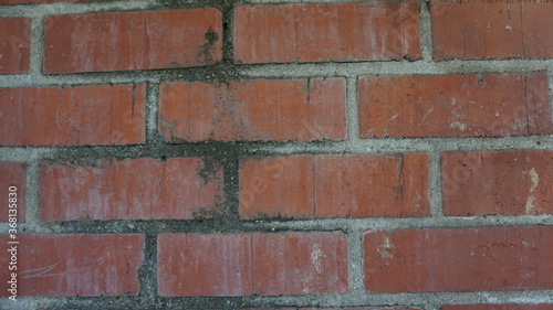 dirty red brick wall with black in grout