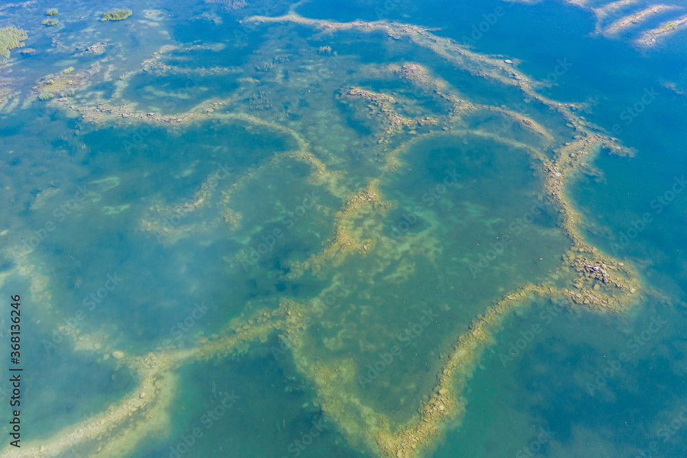 Fototapeta premium Aerial view of a shallow turquoise lake with a raised sandy bottom