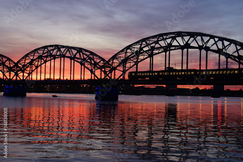 Cityscape of a glowing sky and the Daugava River Railway Bridge in Riga Latvia © organpipecoral