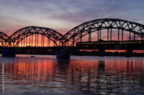 Cityscape of a glowing sky and the Daugava River Railway Bridge in Riga Latvia