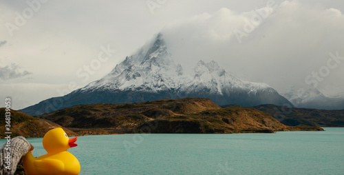 Fotografie View of turquoise lake with jagged mountain peak behind it, and yellow ducky in