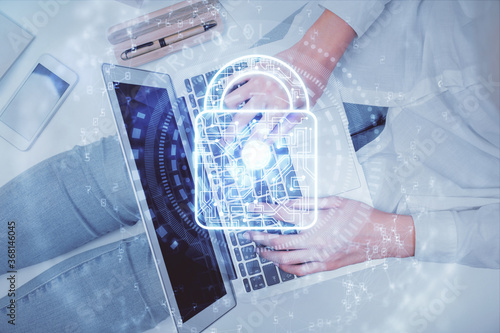 Double exposure of woman hands working on computer and lock hologram drawing. Top View. Security concept.