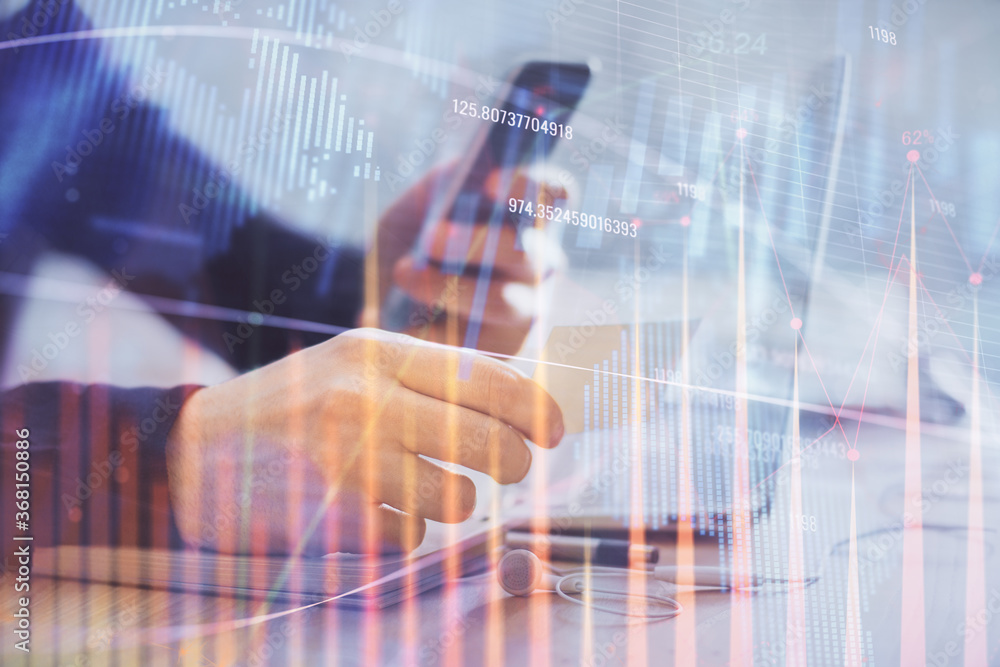 Double exposure of man's hands holding and using a phone and financial graph drawing. Analysis concept. Double exposure of man's hands holding and using a phone and financial graph drawing. Analysis concept.