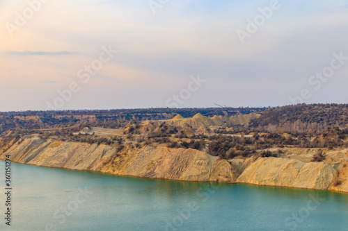 View of a lake with sandy shores in flooded sand quarry