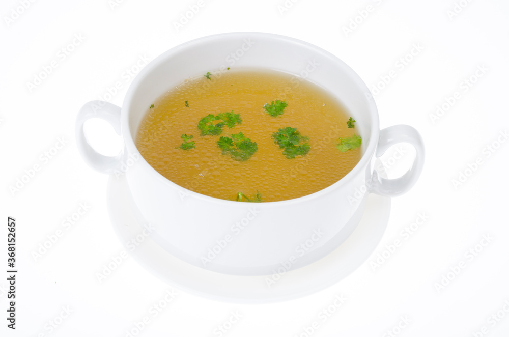 Transparent meat broth with herbs in white plate Transparent meat broth with herbs in white plate