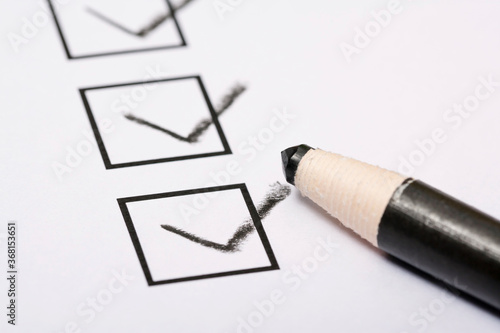 Checklist and pencil close-up on white background 