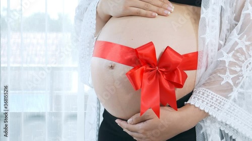 Wallpaper Mural Pregnant woman with red ribbon gift on her belly Torontodigital.ca