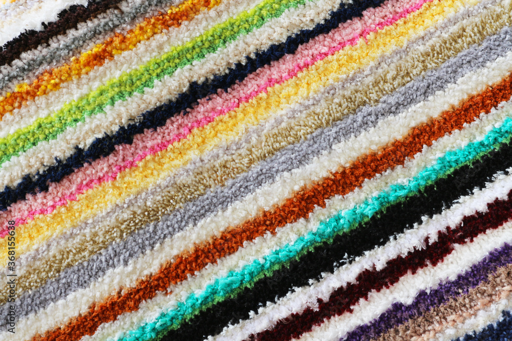 Texture of a multicolored tabby carpet. Abstract striped background.