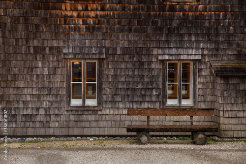 old wooden facade house exterior with park bench