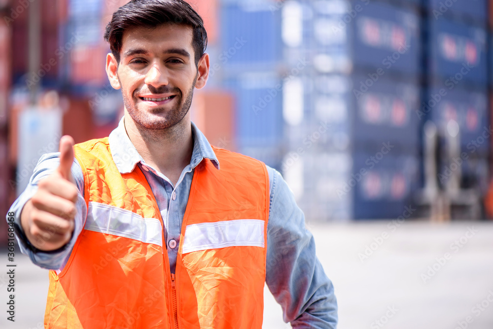 Fototapeta premium Young confident Caucasian man engineer standing with box container background and check for control loading containers box from Cargo freight ship for import and export, transport