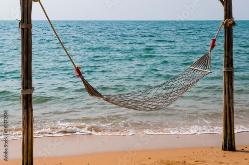 Romantic cozy hammock on the tropical beach by the sea. Peaceful seascape. Relax, travel concept, travelling.
