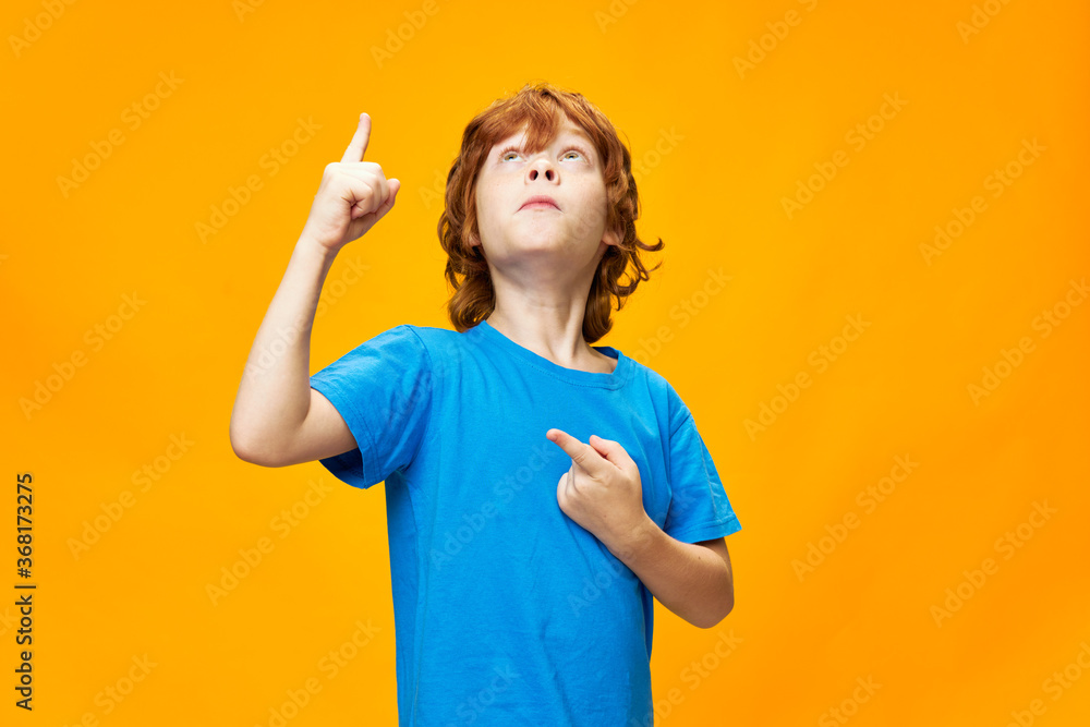 A red-haired boy in a blue T-shirt shows a thumb up A red-haired boy in a blue T-shirt shows a thumb up
