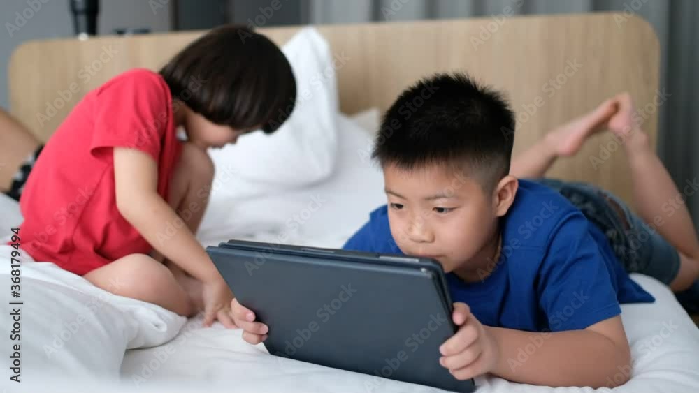 two chinese children addicted tablet, asian child watching telephone together on their bed, kid using smartphone
two chinese children addicted tablet, asian child watching telephone together on their bed, kid using smartphone