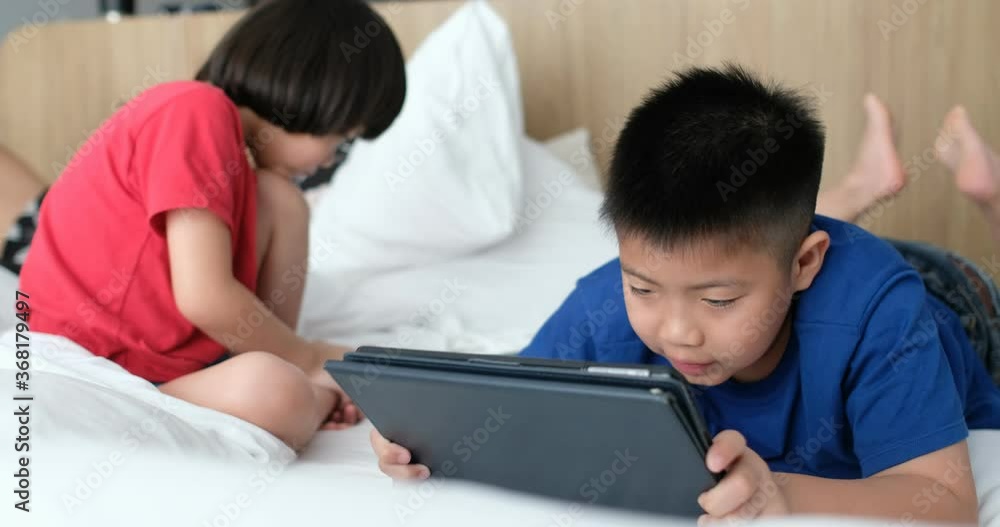 two chinese children addicted tablet, asian child watching telephone together on their bed, kid using smartphone
two chinese children addicted tablet, asian child watching telephone together on their bed, kid using smartphone